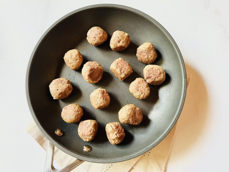 Almôndegas douradas em uma frigideira com azeite.