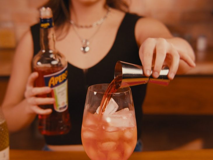 Uma taça contendo a mistura de gelo, espumante e aperol.