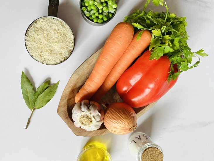 Ingredientes para o arroz à grega com cenoura reunidos em uma bancada.