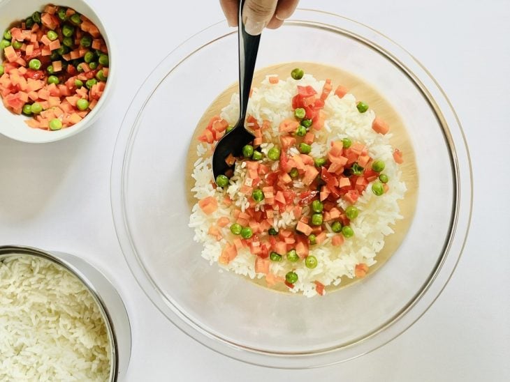 Arroz sendo misturado no refogado.