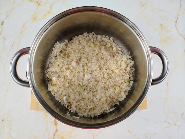 Arroz refogando em uma panela funda.