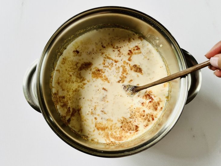 Mistura de leite com caramelo, leite condensado, cravo e canela adicionados à panela com arroz.