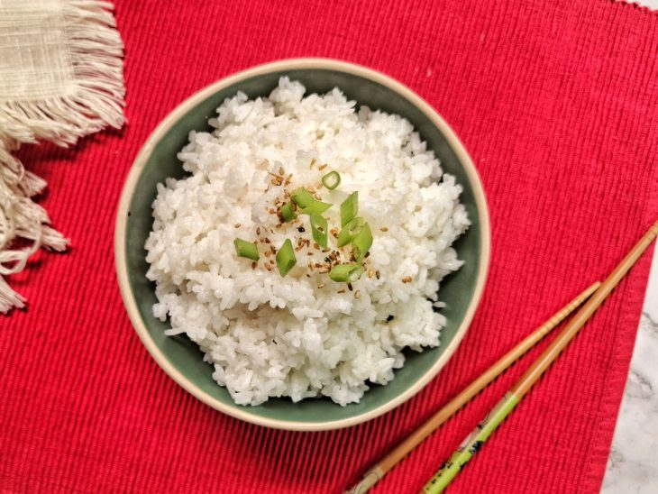 Recipiente com arroz para sushi decorado com salsinha e gergelim.