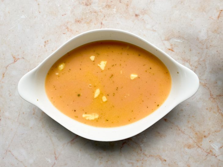 Arroz, creme de leite, molho de tomate, manteiga, caldo de galinha e água quente, adicionados a um recipiente.