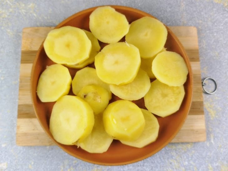 Batatas cozidas cortadas em rodelas sobre um prato.