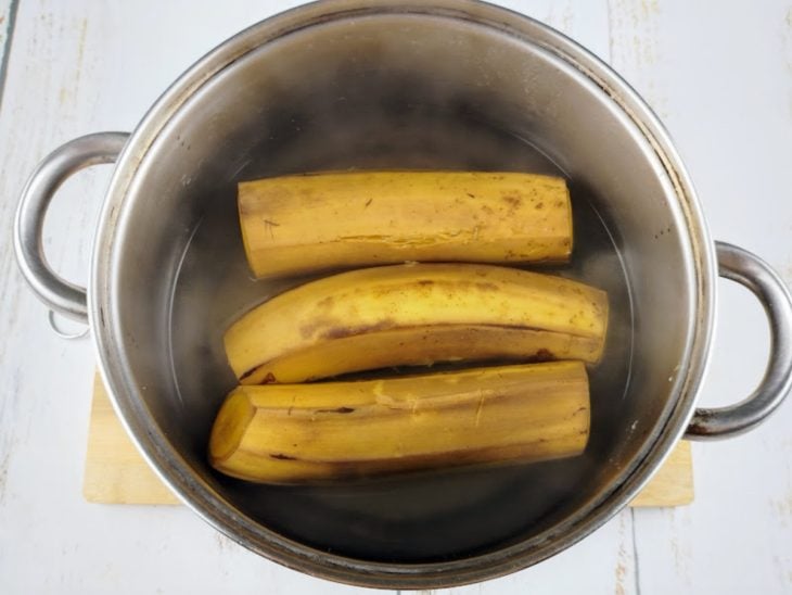 Uma panela com água e bananas cozinhando.