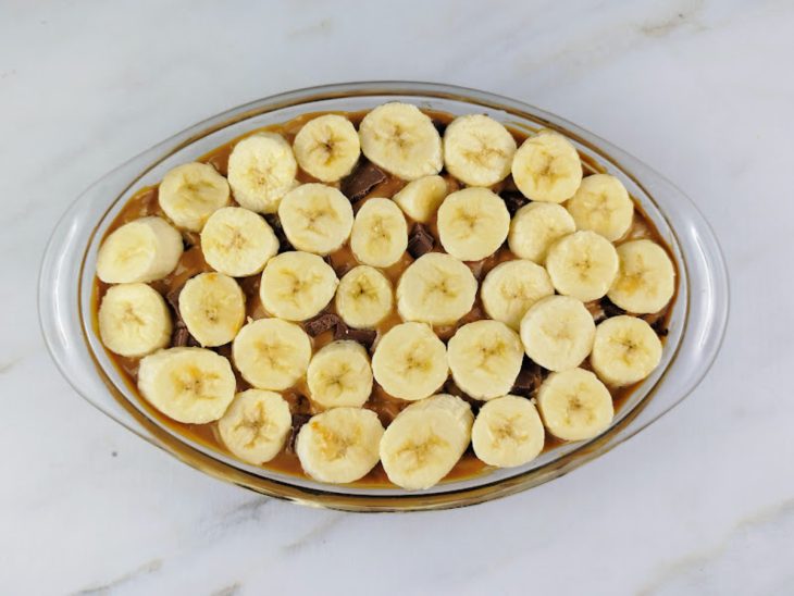 Doce de leite, chocolate e banana adicionados na travessa.