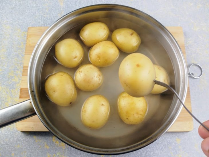 Batatas cozidas em uma frigideira com borda alta e com água