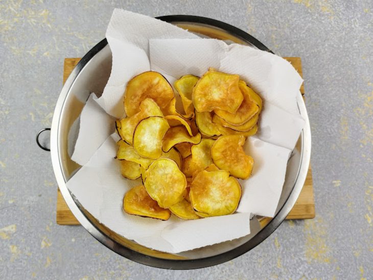 Batata-doce frita e acomodada em um recipiente com papel-toalha.