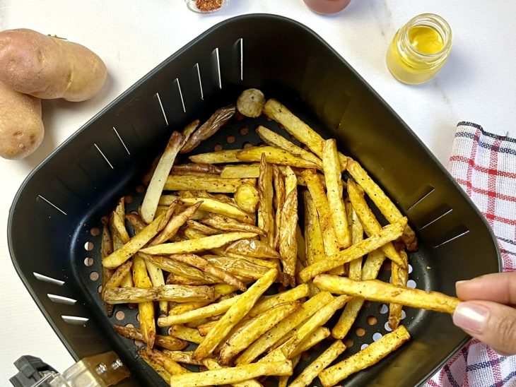 Uma cesta contendo batata frita na airfryer.