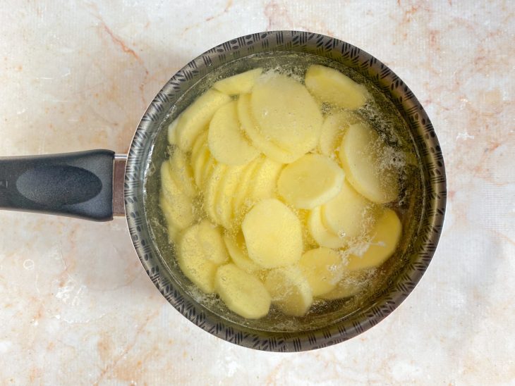 Batatas cozidas em uma panela com água.