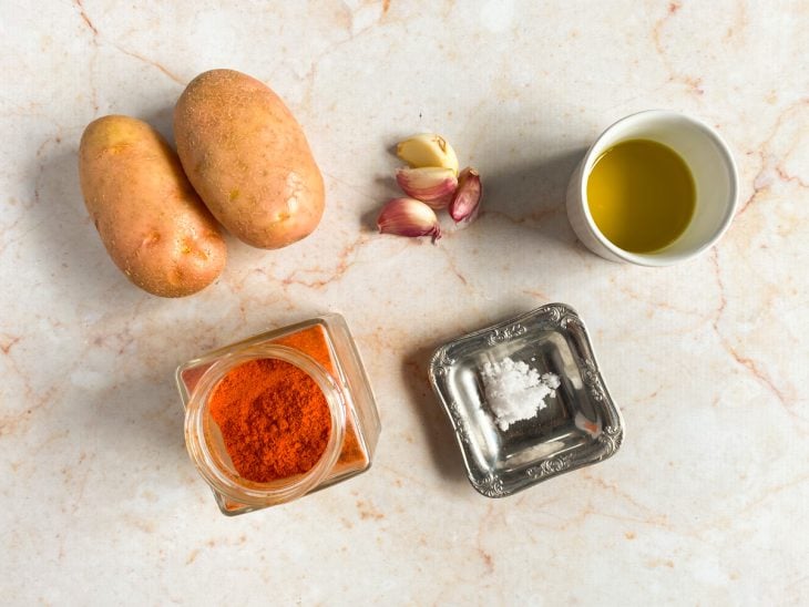 Ingredientes para preparar a batata na air fryer dispostos em uma mesa.