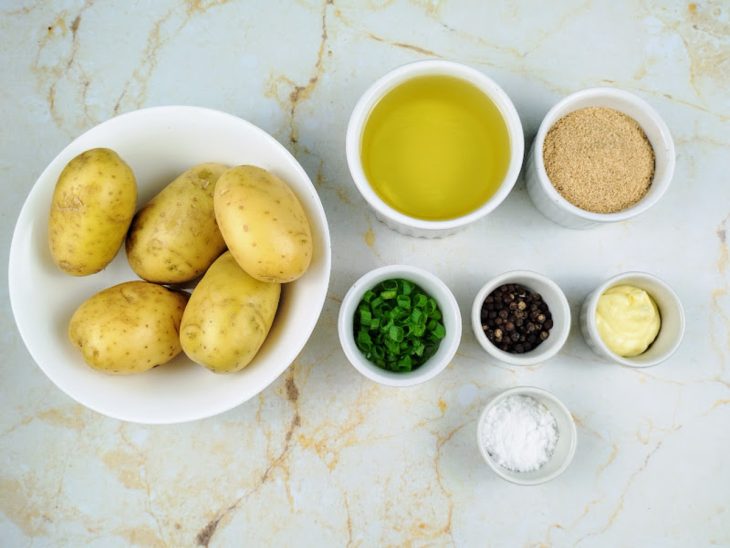 Todos os ingredientes necessários para preparar as batatas noisettes dispostos em uma bancada.