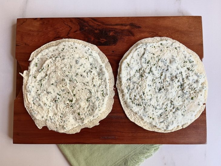 Mistura de iogurte, salsinha picada e sal espalhada nas fatias de pão