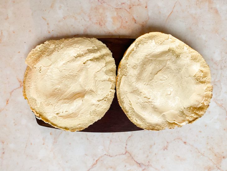 Pão sírio cortado ao meio com maionese passada em ambas as partes.