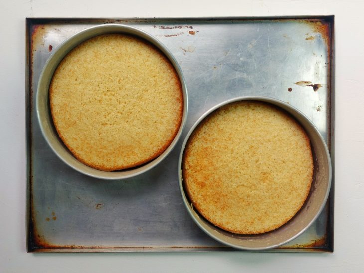 Duas formas contendo massa de bolo assada.