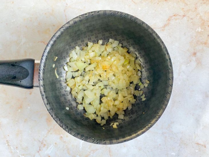 Cebola com óleo em uma panela.