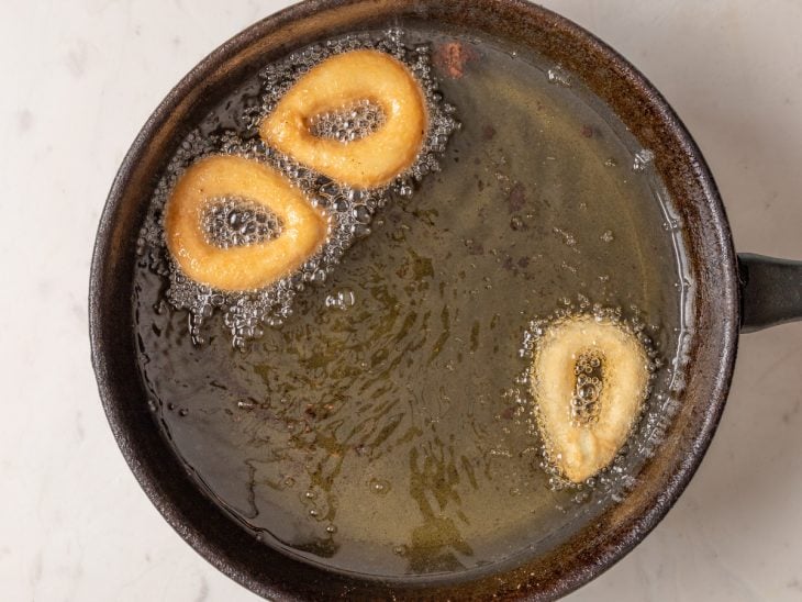 Biscoitos de polvilho doce em uma panela com óleo quente.