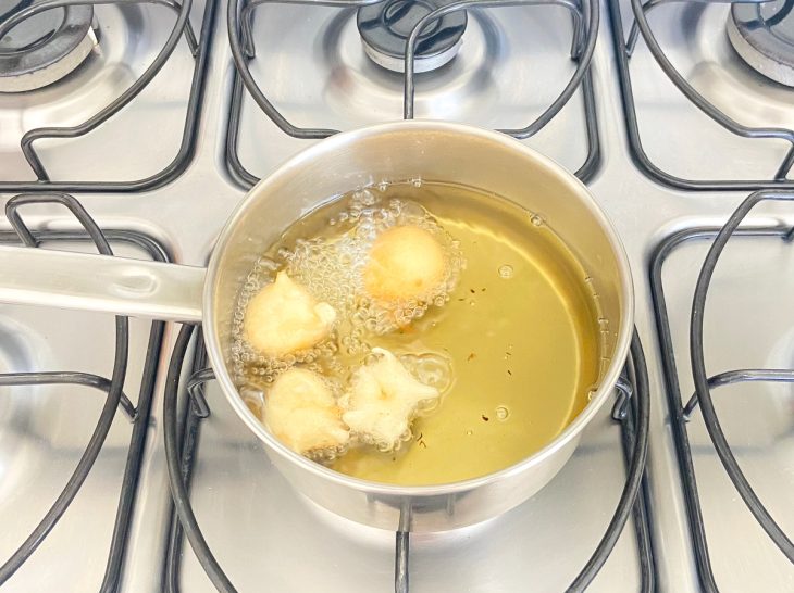 Bolinhos fritando no óleo.