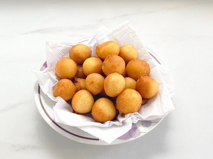 Bolinhos de chuva fácil fritos em um recipiente com papel toalha.