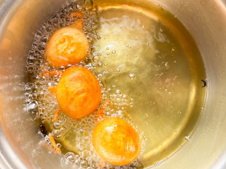 Bolinhos de chuva fritando no óleo.