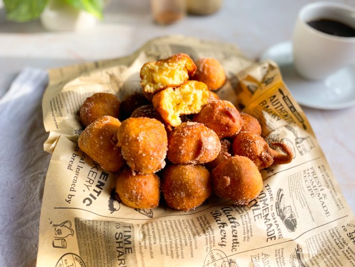 Bolinhos de chuva finalizados no açúcar e canela, prontos para consumo.