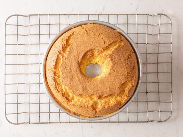 Bolo chiffon de cenoura assado na forma em cima da grade.