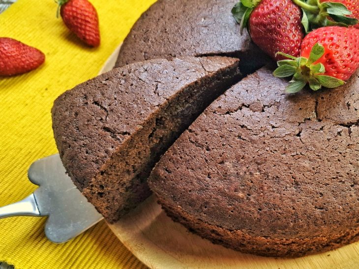 Bolo chiffon de chocolate com uma fatia sendo retirada.