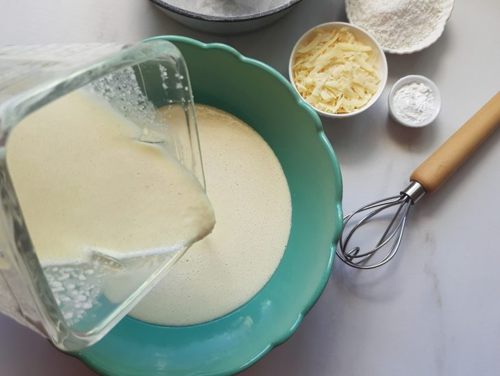 Um liquidificador contendo a mistura de ovos, óleo, leite, açúcar, leite de coco e arroz cozido.