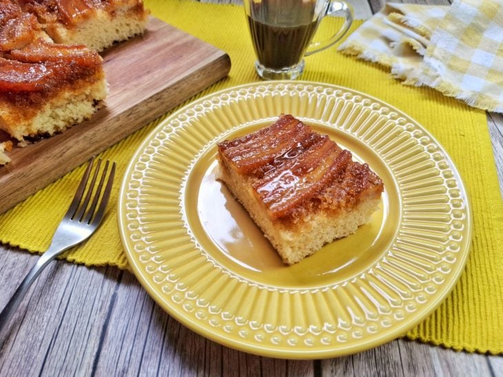 Bolo de banana pronto para consumo, com fatia no prato, pronta para consumo.