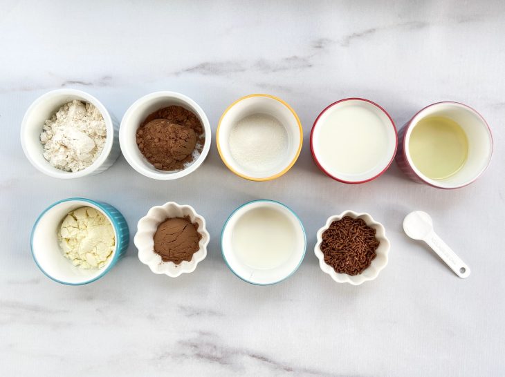 Todos os ingredientes necessários para fazer o bolo de caneca de chocolate sobre o balcão.