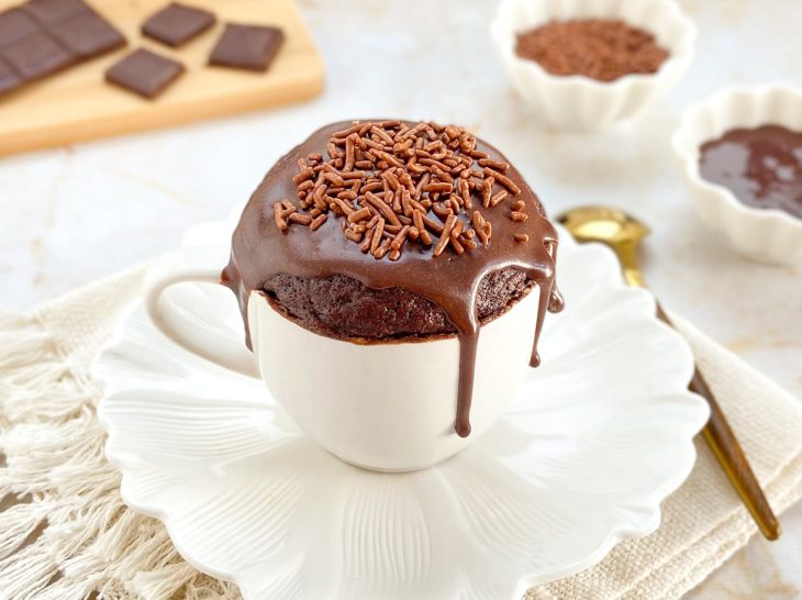 Bolo de caneca de chocolate assado e com a cobertura, pronto para consumo.