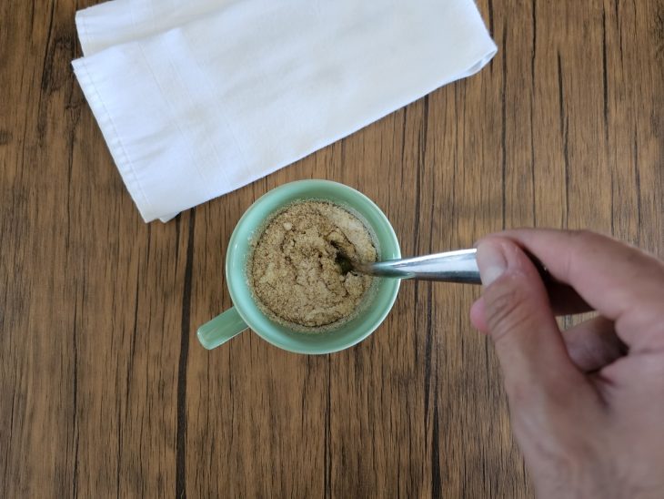 Uma caneca com ovo, farinha de coco, farinha de maracujá e xilitol.