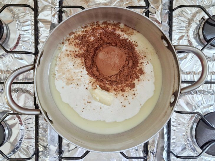 Panela com leite condensado, creme de leite, margarina e chocolate em pó.