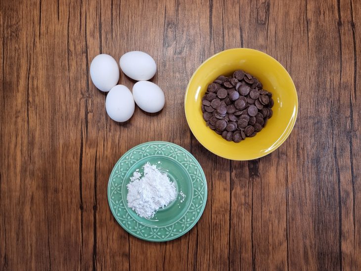 Ovos, chocolate e açúcar de confeiteiro reunidos para o preparo do bolo