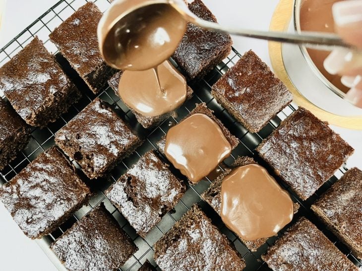 Pedaços de bolo cortados e banhados por calda de chocolate.