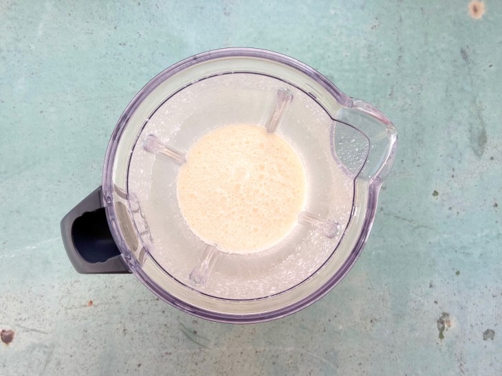 Um liquidificador contendo a mistura de leite, o ovo, açúcar e manteiga.