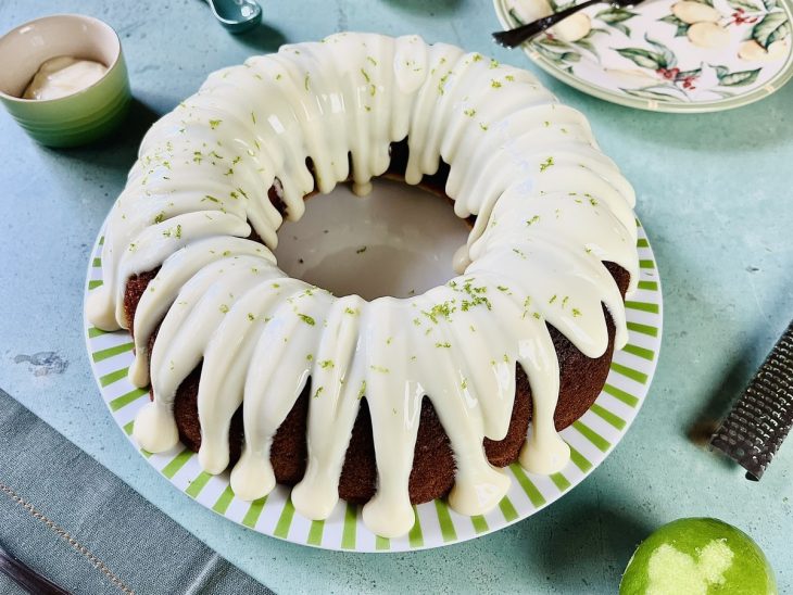 Bolo de limão rápido pronto para servir, finalizado com calda e raspas de limão.