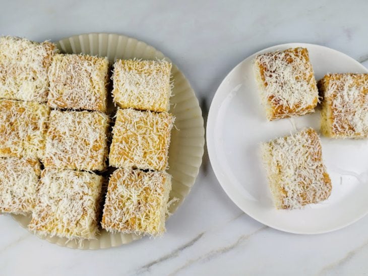 Pedaços do bolo molhados na calda e empanados no coco.