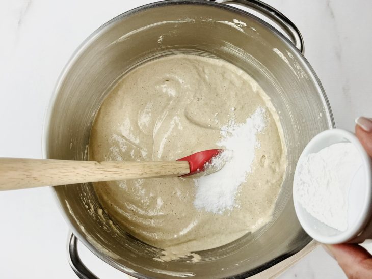 Farinha de rosca e fermento em pó adicionados a tigela da batedeira.