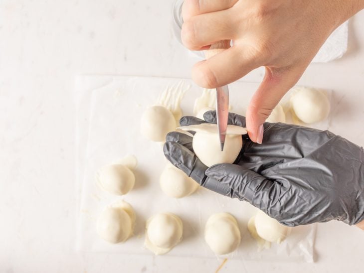 Bombons recebendo acabamento com a ajuda de uma faca.