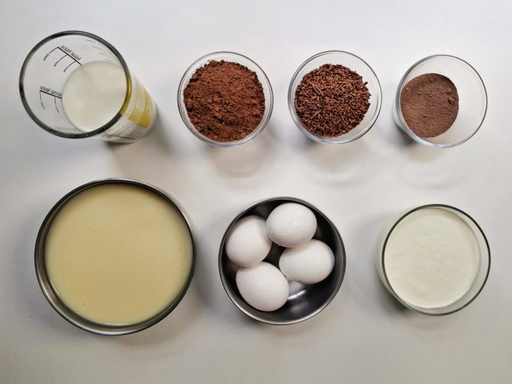 Ingredientes para a receita de brigadeirão sem banho-maria separados em uma bancada.