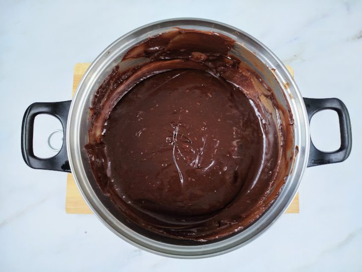 Uma panela com a mistura de creme de leite, leite condensado, chocolate em pó chocolate meio amargo e manteiga.