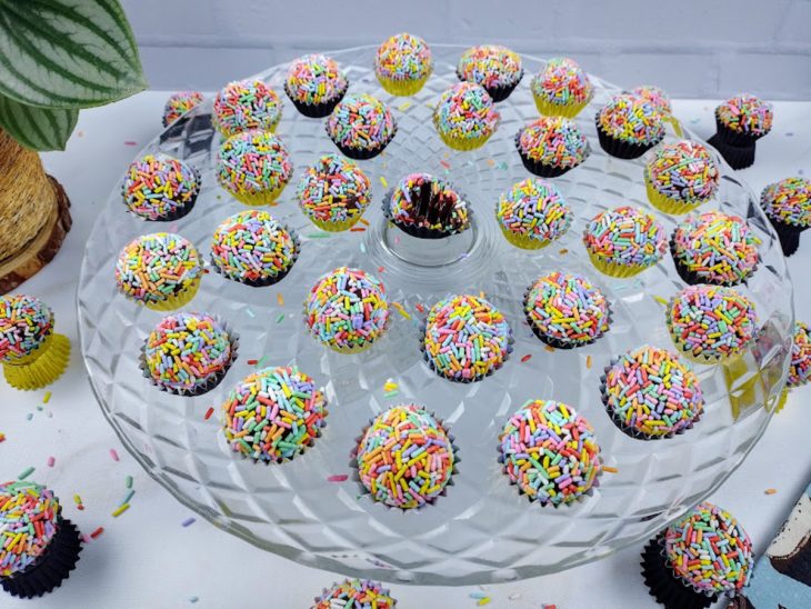 Um prato contendo brigadeiro com granulado colorido.