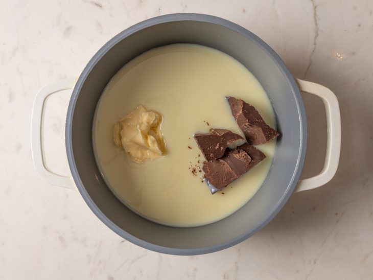 Leite condensado, manteiga e chocolate em uma panela.