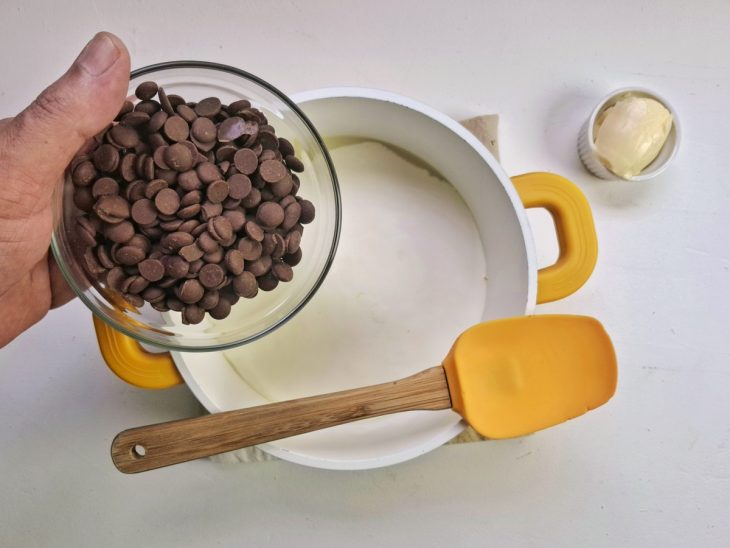 Panela com leite condensado, manteiga e chocolate na panela.