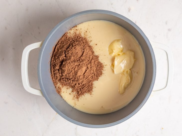 Uma panela com leite condensado, manteiga e chocolate em pó.