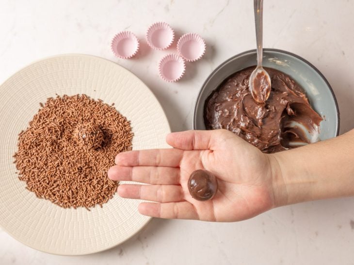 Brigadeiro enrolado e envolto por granulado.