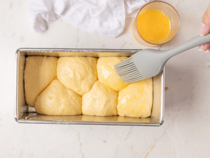 Brioche sendo pincelado com ovo.