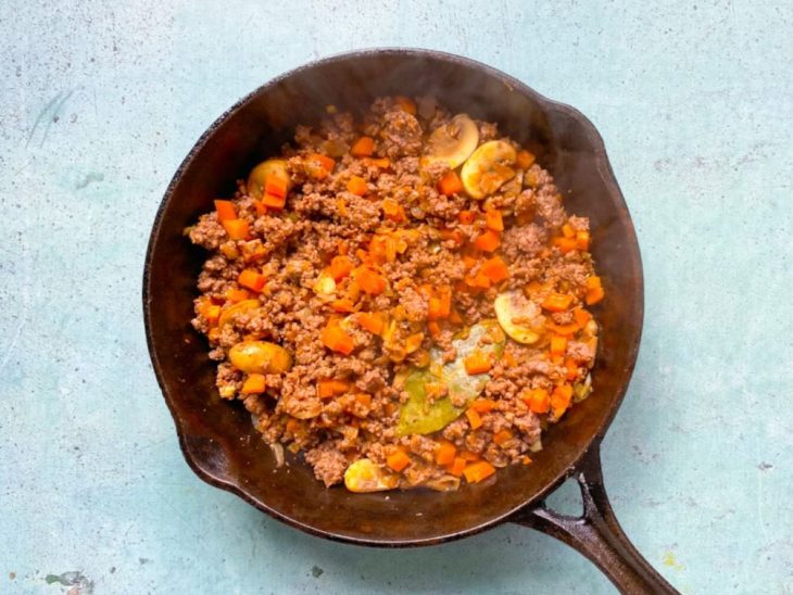 Frigideira de ferro com carne moída temperada.